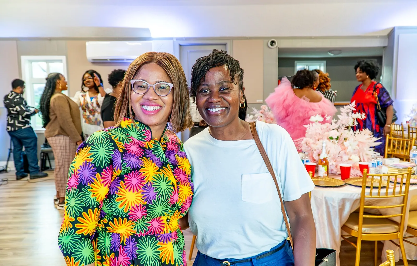 Two women smiling warmly together during a church gathering